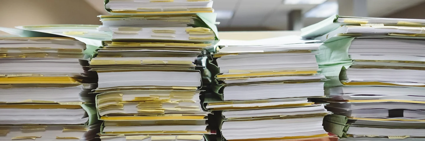 Stacks of paper documents and file folders